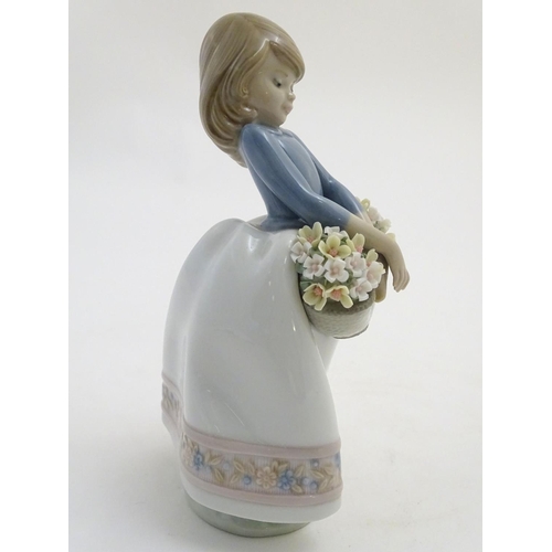 80 - A Lladro figure of a girl with a basket of flowers, May Flowers Girl, model no. 5467. Marked under. ... 