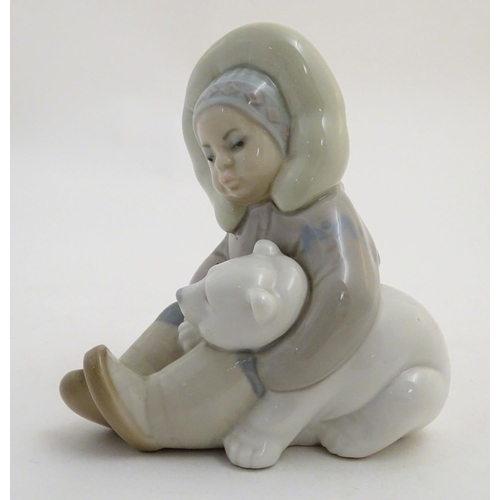 82 - A Lladro figure of an Eskimo girl with a polar bear, model no. 1195. Marked under. Approx. 4 3/4