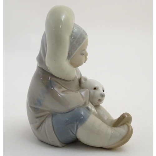 82 - A Lladro figure of an Eskimo girl with a polar bear, model no. 1195. Marked under. Approx. 4 3/4