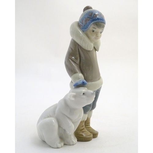 83 - A Lladro figure of a boy with a polar bear cub, model no. 5238. Approx. 5 3/4