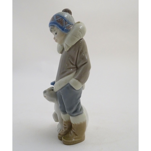 83 - A Lladro figure of a boy with a polar bear cub, model no. 5238. Approx. 5 3/4