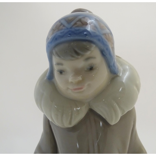 83 - A Lladro figure of a boy with a polar bear cub, model no. 5238. Approx. 5 3/4