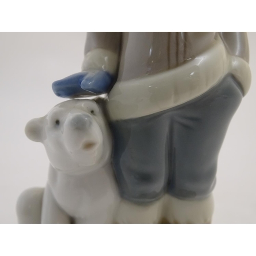 83 - A Lladro figure of a boy with a polar bear cub, model no. 5238. Approx. 5 3/4