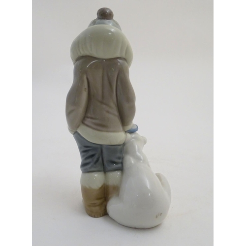 83 - A Lladro figure of a boy with a polar bear cub, model no. 5238. Approx. 5 3/4