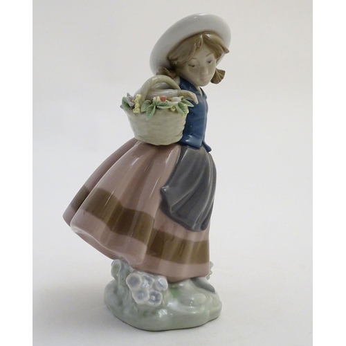 84 - A Lladro figure of a girl holding a basket of flowers, Sweet Scent, model no. 5221. Marked under. Ap... 