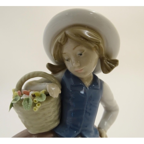 84 - A Lladro figure of a girl holding a basket of flowers, Sweet Scent, model no. 5221. Marked under. Ap... 