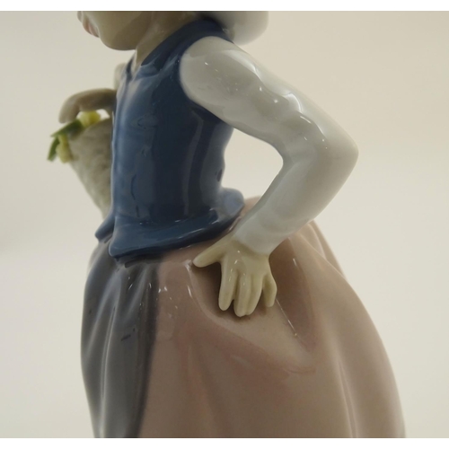 84 - A Lladro figure of a girl holding a basket of flowers, Sweet Scent, model no. 5221. Marked under. Ap... 