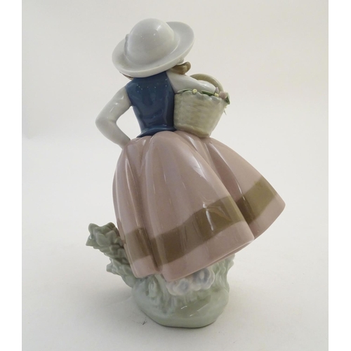 84 - A Lladro figure of a girl holding a basket of flowers, Sweet Scent, model no. 5221. Marked under. Ap... 