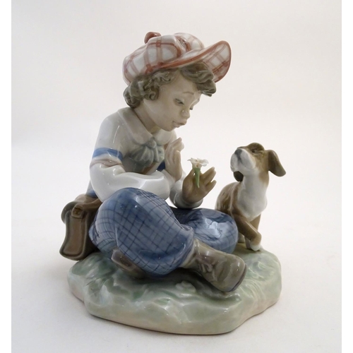 85 - A Lladro figure of a boy with a dog pulling flower petals, I Hope She Does, model no. 5450. Marked u... 