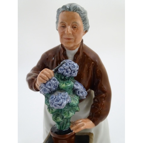 94 - A Royal Doulton figurine depicting an old woman with flowers, Flora, model number 2349. Marked under... 