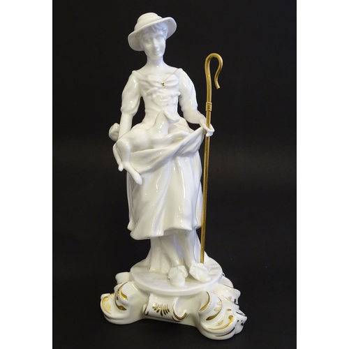 97 - A Royal Crown Derby white glazed female figure modelled as a shepherdess, with a crook and holding l... 