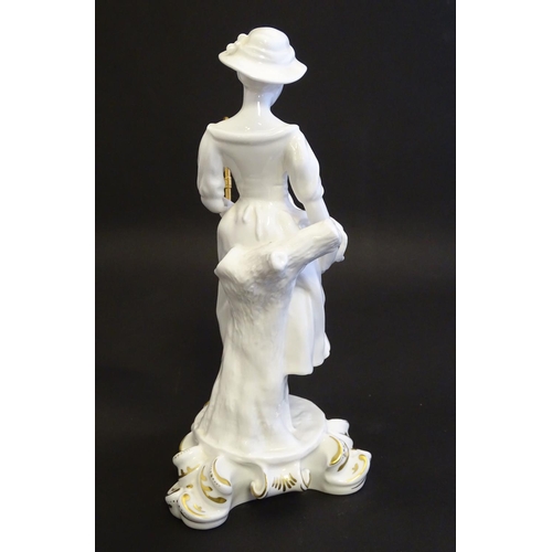 97 - A Royal Crown Derby white glazed female figure modelled as a shepherdess, with a crook and holding l... 