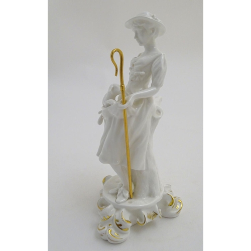 97 - A Royal Crown Derby white glazed female figure modelled as a shepherdess, with a crook and holding l... 