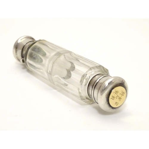 215 - A 19thC double ended scent bottle / flask the class body with with  white metal ends and yellow meta... 