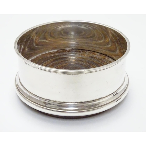 224 - A silver coaster with turned wooden base. Hallmarked Birmingham 1987 maker Argyll Silver. 4