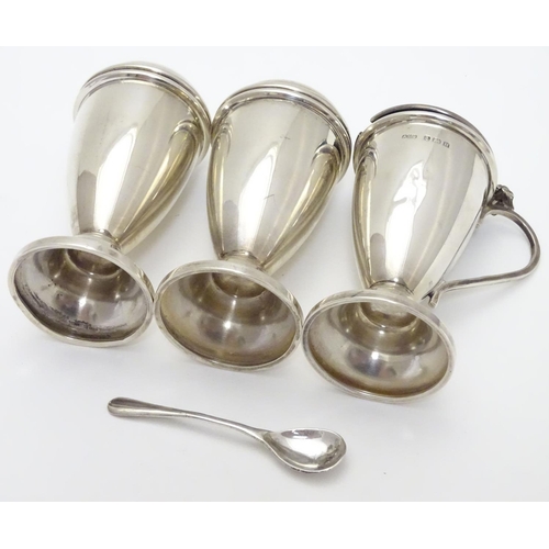 237 - An Art Deco silver three piece cruet set comprising salt, pepper and mustard pot (with spoon and fac... 