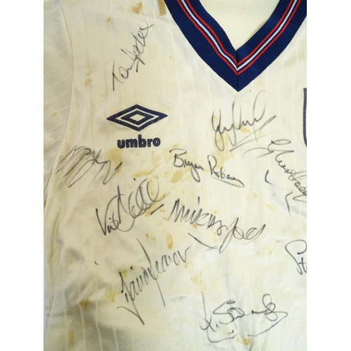 87 - Football: A Child's size 1986 England shirt, signed by: Bobby Robson , Peter Beardsley , Gary Lineke... 