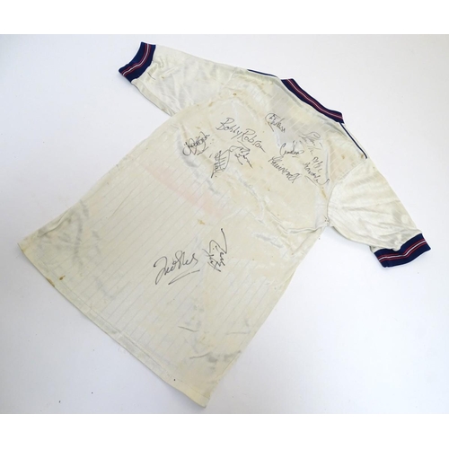87 - Football: A Child's size 1986 England shirt, signed by: Bobby Robson , Peter Beardsley , Gary Lineke... 