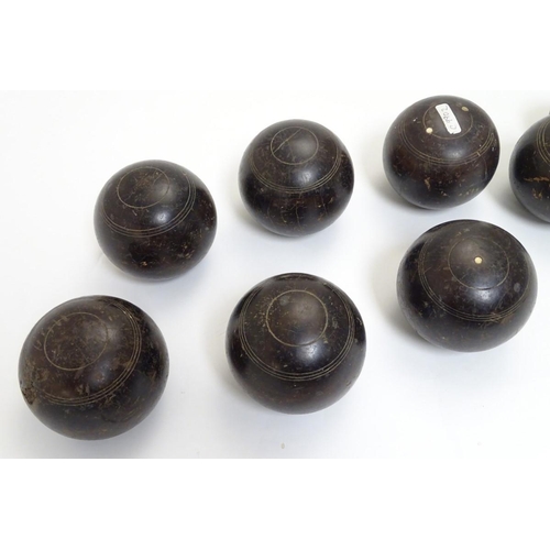 97 - Seven early 20thC lignum vitae bowls, each approximately 4 1/2'' in diameter. Together with two hard... 