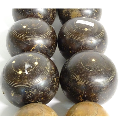 97 - Seven early 20thC lignum vitae bowls, each approximately 4 1/2'' in diameter. Together with two hard... 