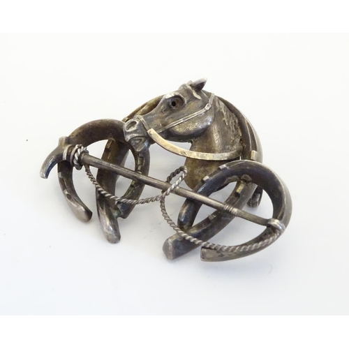 226 - A white metal brooch front. Formed as three horseshoes with horse head and riding crop decoration 1 ... 