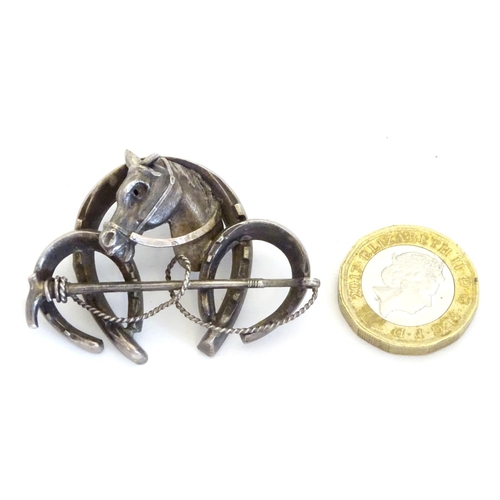 226 - A white metal brooch front. Formed as three horseshoes with horse head and riding crop decoration 1 ... 