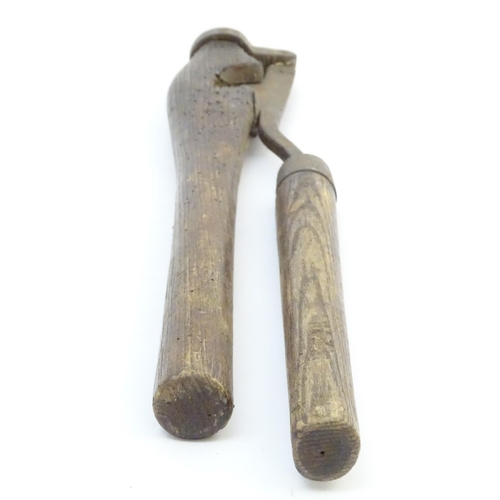 114 - A Victorian tail docking cutting clamp, the blade and hinge mounted to hardwood handles. 23 1/4