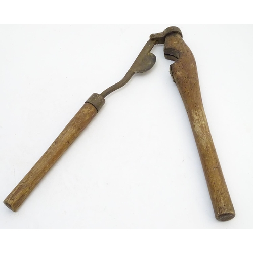 114 - A Victorian tail docking cutting clamp, the blade and hinge mounted to hardwood handles. 23 1/4