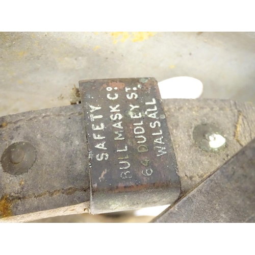 115 - Farming bygone: a galvanised steel bull headplate, the strap labelled 'Safety Bull Mask Co., 64 Dudl... 