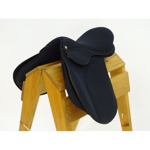 373 - A black narrow synthetic horse riding / equestrian saddle. Approx. 17