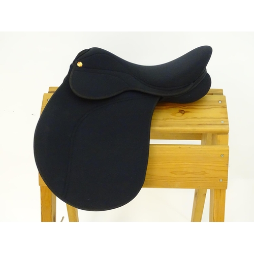 373 - A black narrow synthetic horse riding / equestrian saddle. Approx. 17