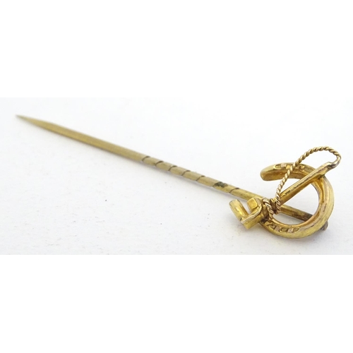 278 - A yellow metal stick pin surmounted by horseshoe with riding whip decoration 2