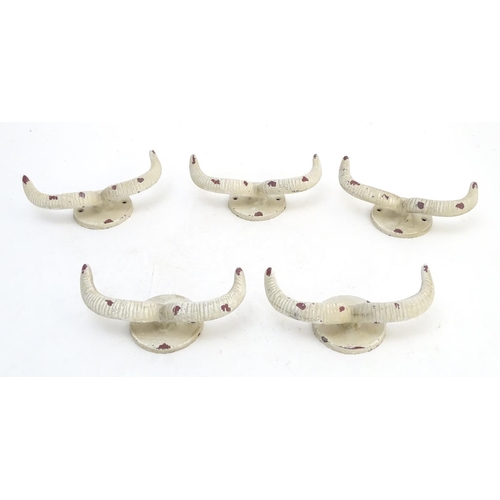 293 - Five cast wall hanging coat hooks formed as stylised rams horns with painted decoration. Approx. 7 3... 