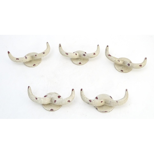293 - Five cast wall hanging coat hooks formed as stylised rams horns with painted decoration. Approx. 7 3... 