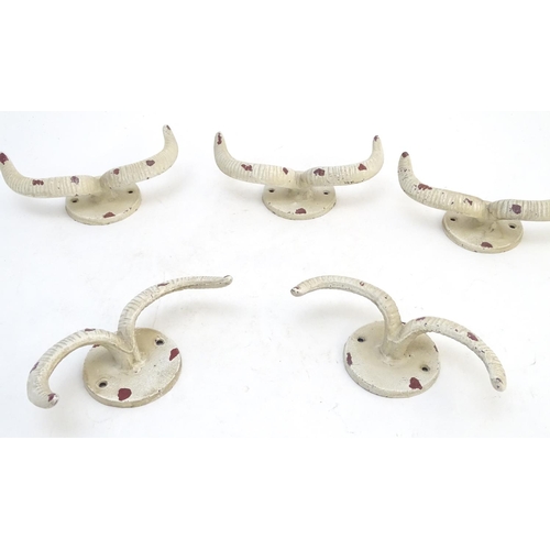 293 - Five cast wall hanging coat hooks formed as stylised rams horns with painted decoration. Approx. 7 3... 