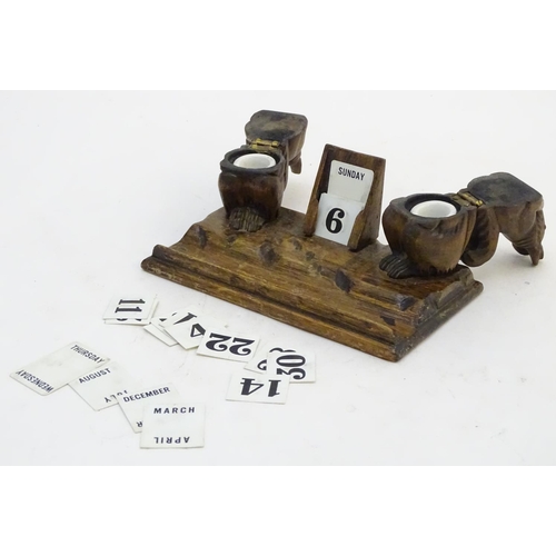 298 - A carved wooden desk calendar and standish / inkwell, the inkwells formed as squirrels eating nuts. ... 