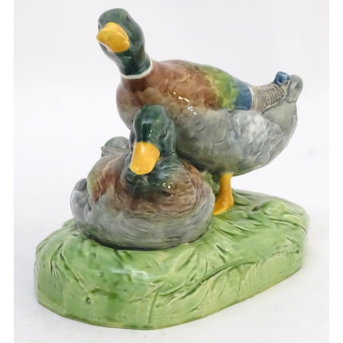 306 - A large ceramic model formed as two ducks on an oval base, one sitting, one standing. Impressed 1264... 