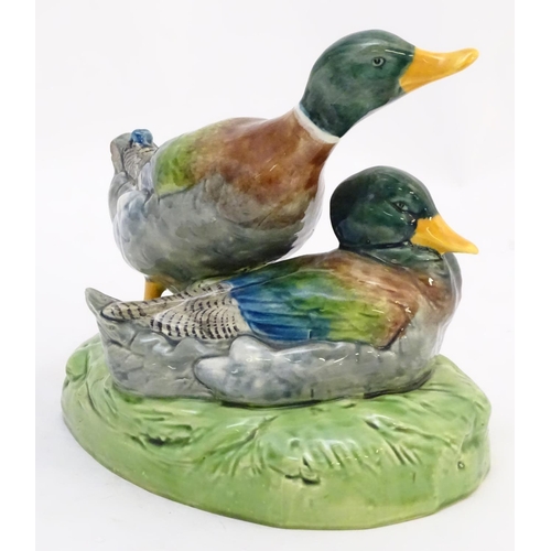 306 - A large ceramic model formed as two ducks on an oval base, one sitting, one standing. Impressed 1264... 