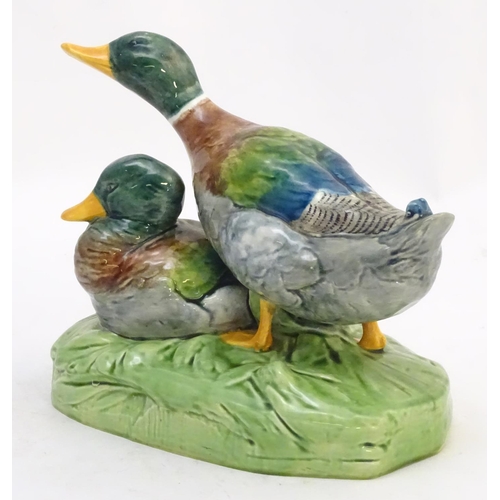 306 - A large ceramic model formed as two ducks on an oval base, one sitting, one standing. Impressed 1264... 