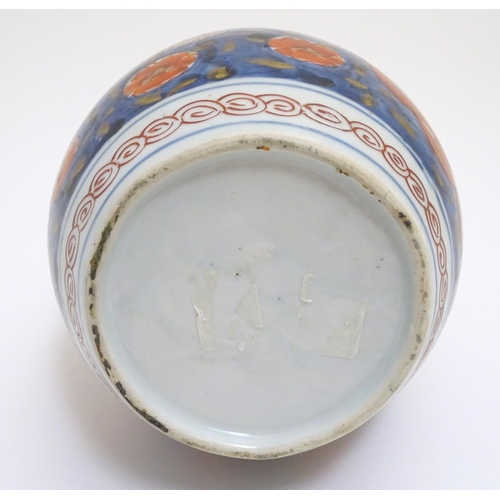 1 - An Oriental double gourd vase in the Imari palette with lobed panels depicting plants on a terrace, ... 