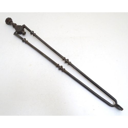 1031 - A Victorian pair of cast iron fire tongs, 27