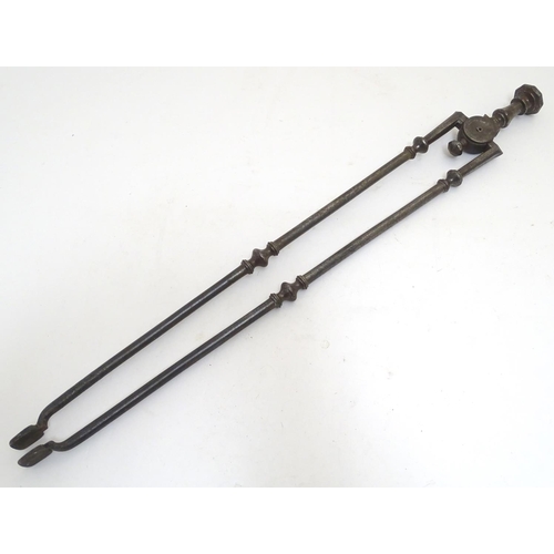 1031 - A Victorian pair of cast iron fire tongs, 27