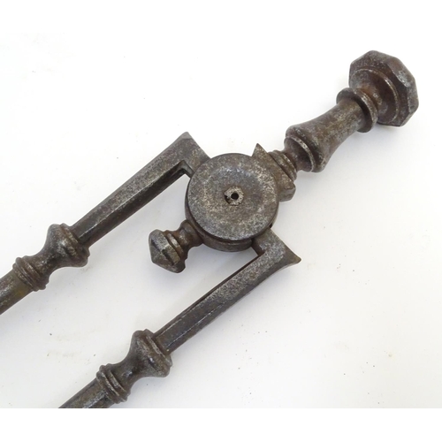 1031 - A Victorian pair of cast iron fire tongs, 27