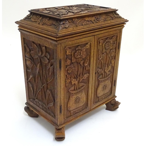 1032 - A 19thC Chinese hardwood table cabinet, with carved foliate and floral decoration, the lid with depi... 