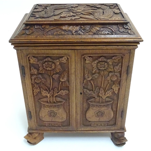 1032 - A 19thC Chinese hardwood table cabinet, with carved foliate and floral decoration, the lid with depi... 