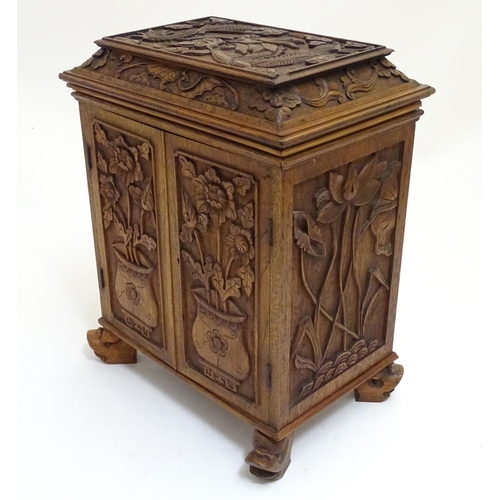 1032 - A 19thC Chinese hardwood table cabinet, with carved foliate and floral decoration, the lid with depi... 