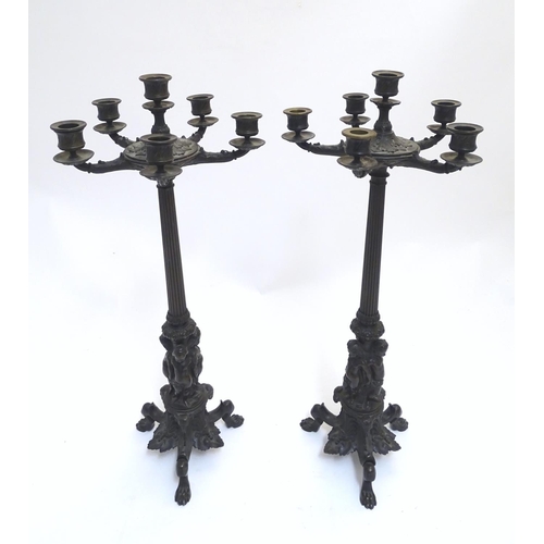 1033 - A pair of Regency bronze candelabra, the fluted columns supporting a series of five candle cups enci... 