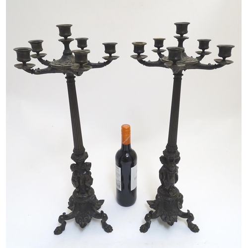 1033 - A pair of Regency bronze candelabra, the fluted columns supporting a series of five candle cups enci... 