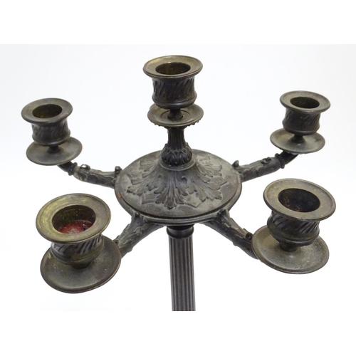 1033 - A pair of Regency bronze candelabra, the fluted columns supporting a series of five candle cups enci... 