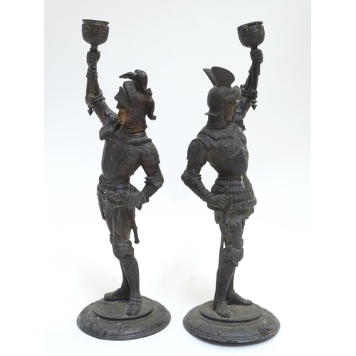 1035 - A pair of early 20thC candlesticks formed as French armoured knights, each measuring 15